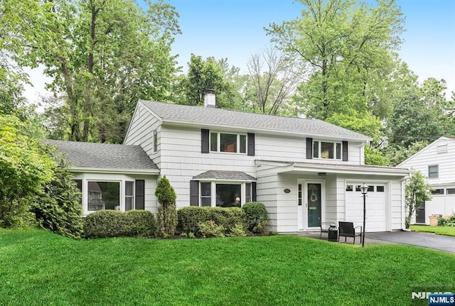 960 Andover Ter, Ridgewood, NJ 07450 - traditional-style house featuring asphalt driveway, a chimney, a front lawn, a garage, and a shingled roof