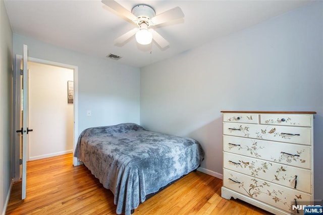 bedroom with light wood-style flooring, baseboards, and a ceiling fan