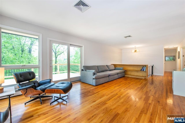 living area featuring light wood-style floors and a chandelier