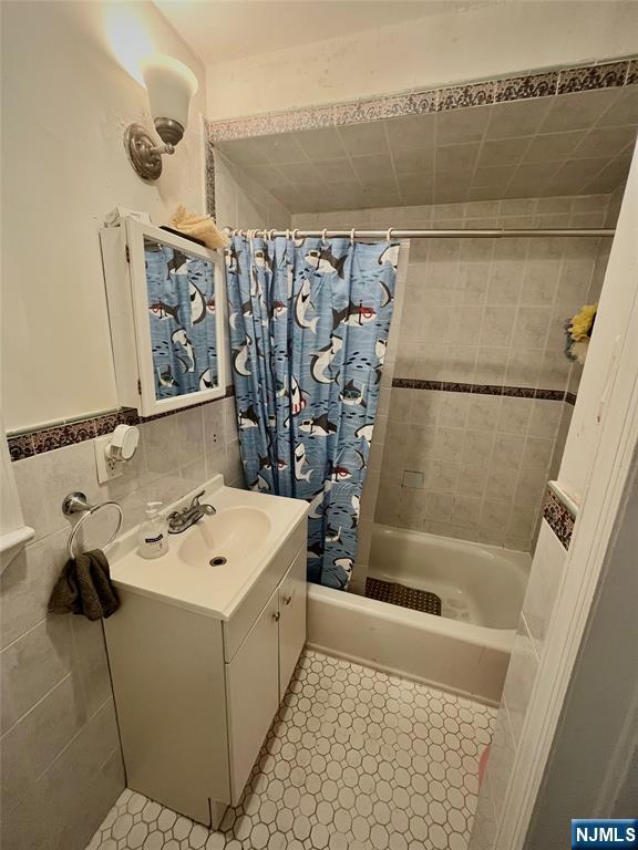 398 Cliff St, Fairview, NJ 07022 - full bath with shower / bath combination with curtain, vanity, and tile walls