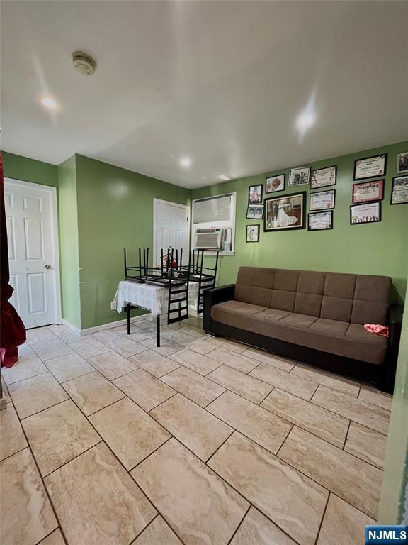 398 Cliff St, Fairview, NJ 07022 - living room featuring cooling unit, light tile patterned floors, and baseboards