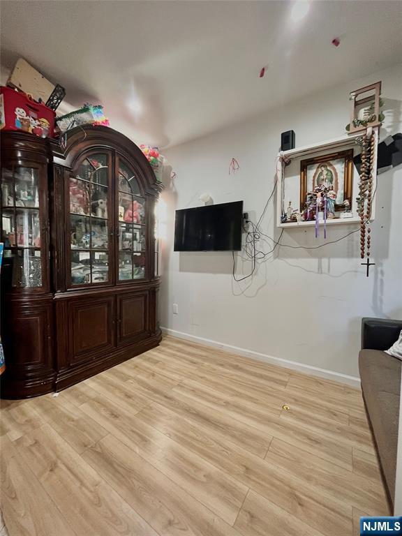 398 Cliff St, Fairview, NJ 07022 - unfurnished living room with wood finished floors and baseboards