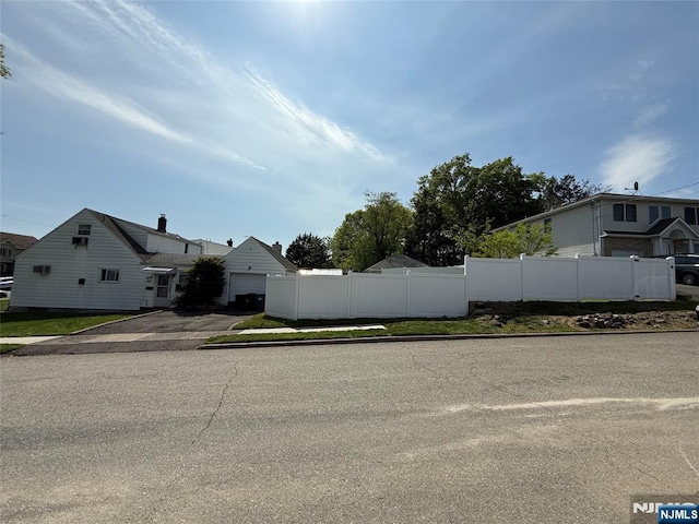 view of front facade with fence, driveway, and a garage