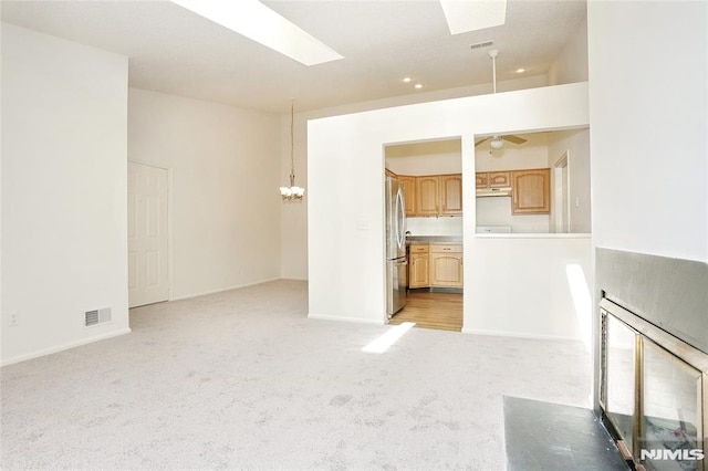 398 Poets Way Unit 398, Mahwah, NJ 07430 - unfurnished living room with light carpet, a skylight, a chandelier, and a ceiling fan