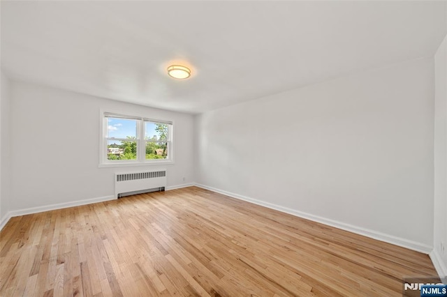 7 Edgewater Pl, Edgewater, NJ 07020 - unfurnished room featuring radiator, light wood finished floors, and baseboards