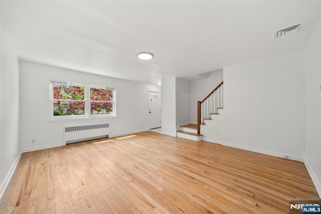 7 Edgewater Pl, Edgewater, NJ 07020 - unfurnished living room featuring radiator, light wood-type flooring, stairway, and baseboards