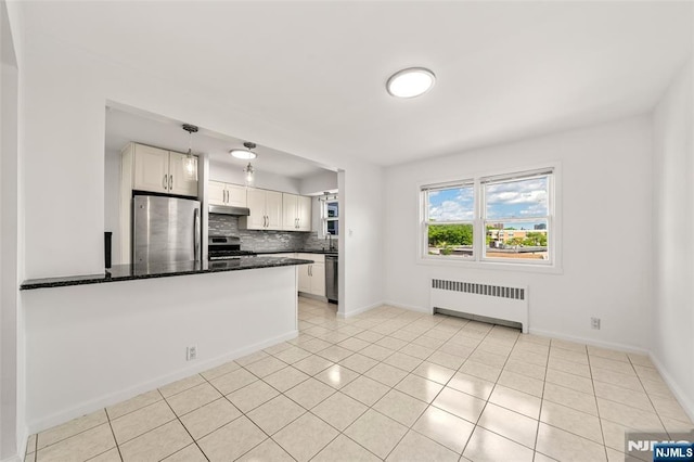 7 Edgewater Pl, Edgewater, NJ 07020 - kitchen featuring radiator, appliances with stainless steel finishes, under cabinet range hood, white cabinetry, and backsplash