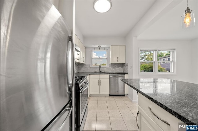 7 Edgewater Pl, Edgewater, NJ 07020 - kitchen with appliances with stainless steel finishes, tasteful backsplash, light tile patterned flooring, a sink, and white cabinets