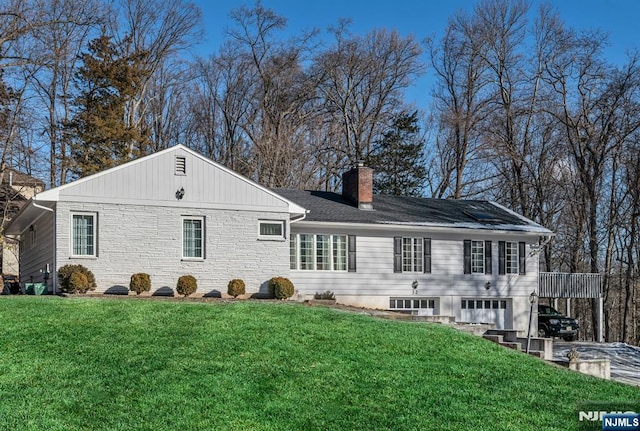 32 Brookside Dr, Upper Saddle River, NJ 07458 - rear view of property featuring a chimney, a lawn, and a garage