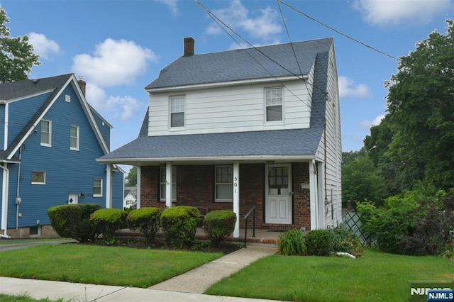 501 Collins Ave, Hasbrouck Heights, NJ 07604 - view of front facade featuring brick siding, a front yard, a chimney, and a porch