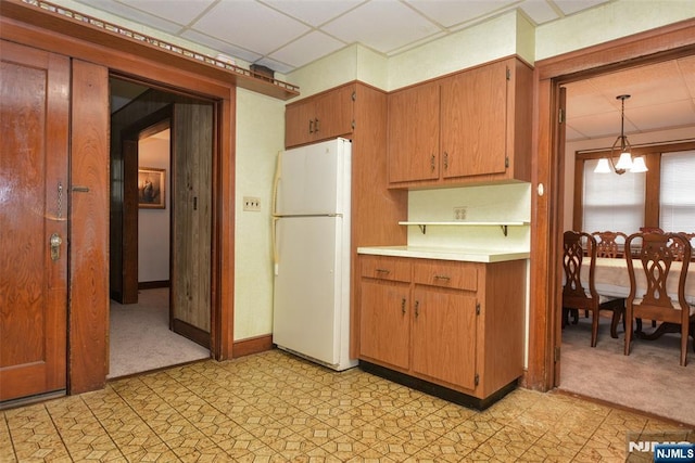501 Collins Ave, Hasbrouck Heights, NJ 07604 - kitchen with freestanding refrigerator, a chandelier, light countertops, light colored carpet, and a drop ceiling