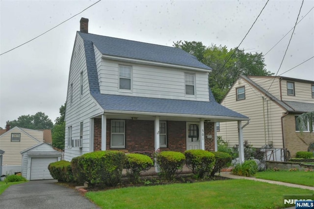 501 Collins Ave, Hasbrouck Heights, NJ 07604 - view of front of house featuring an outbuilding, a chimney, a front yard, asphalt driveway, and brick siding