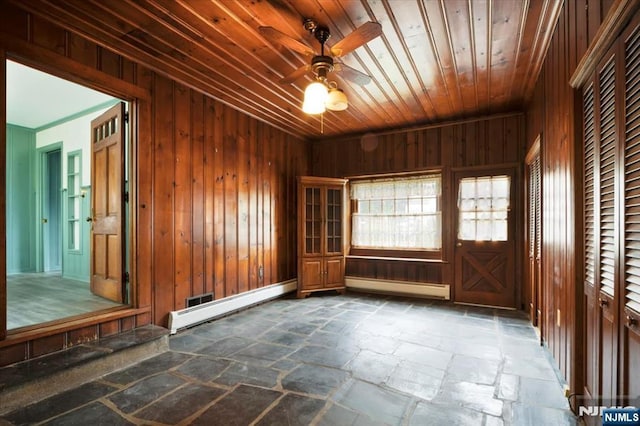35 Mccosh Rd, Clifton, NJ 07043 - unfurnished room featuring stone tile flooring, a baseboard heating unit, a ceiling fan, wood walls, and wood ceiling