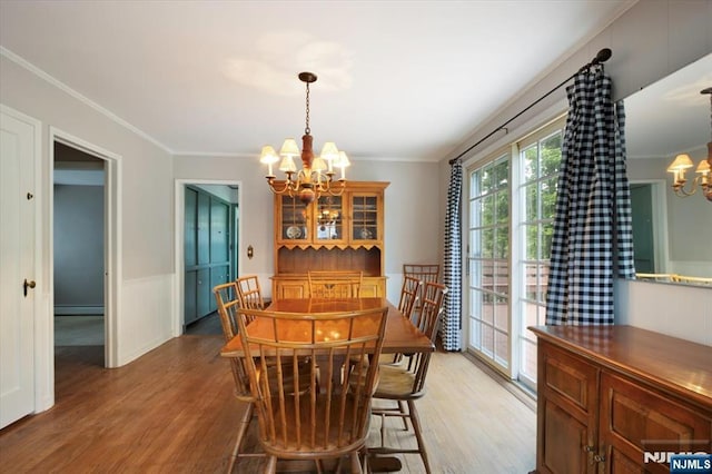35 Mccosh Rd, Clifton, NJ 07043 - dining space featuring a chandelier, light wood finished floors, crown molding, baseboard heating, and wainscoting