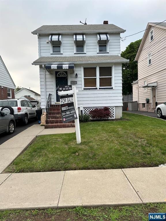 31 Colling Ave, Rochelle Park, NJ 07662 - view of front of house with a front yard, roof with shingles, and a chimney