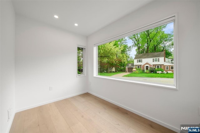 spare room featuring baseboards, wood finished floors, and recessed lighting