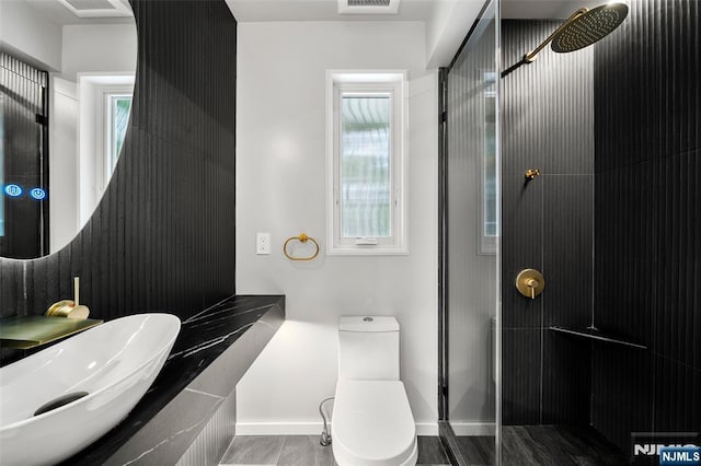 full bathroom featuring a shower, toilet, a sink, and baseboards