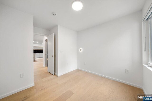 unfurnished bedroom with light wood-style flooring and baseboards