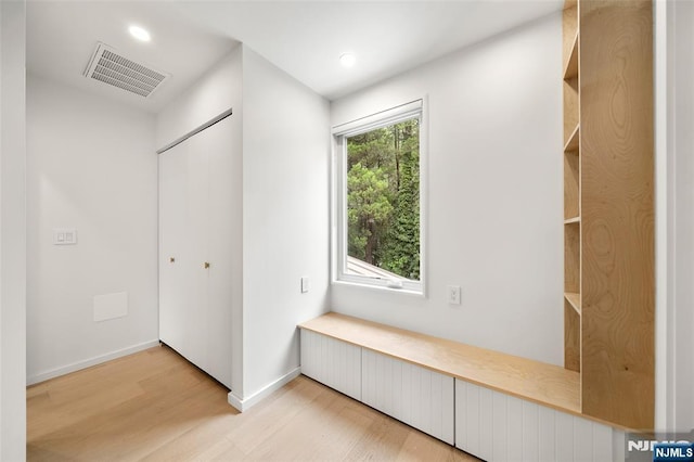 hallway featuring light wood finished floors, recessed lighting, and baseboards