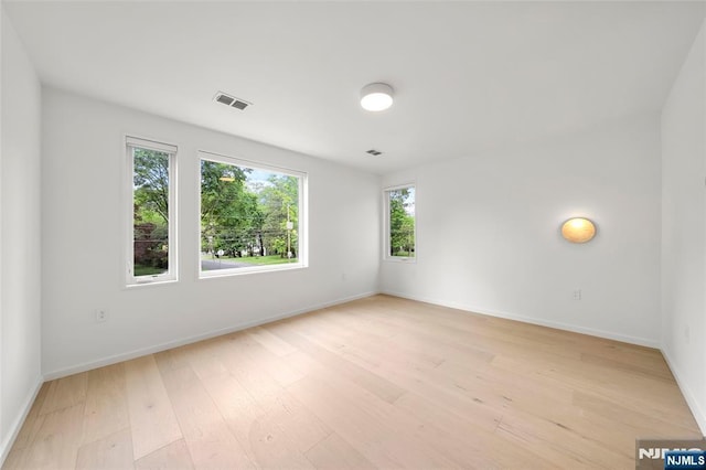 spare room featuring light wood-style floors and baseboards