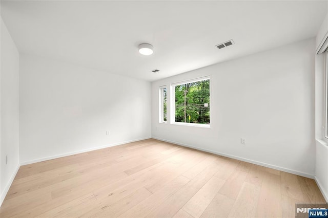 empty room featuring light wood-type flooring and baseboards