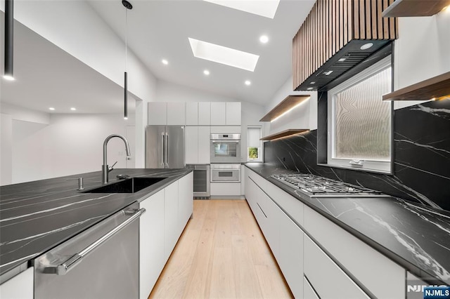 kitchen with open shelves, appliances with stainless steel finishes, a sink, modern cabinets, and dark countertops