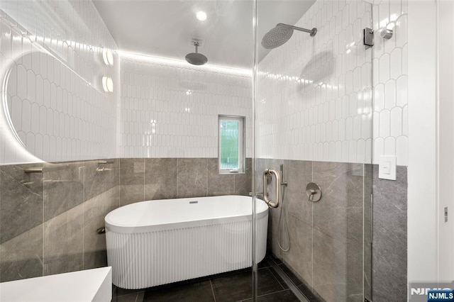 full bath featuring tile walls, walk in shower, a soaking tub, and tile patterned floors