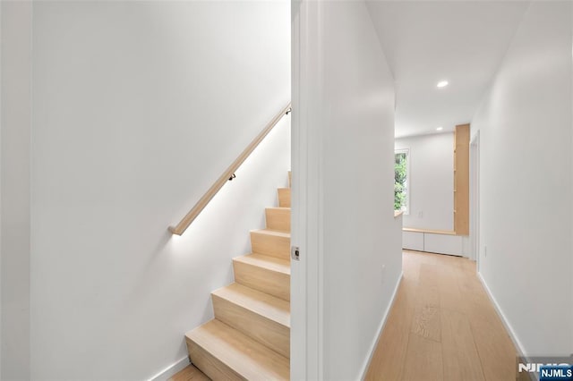 stairway featuring wood finished floors, recessed lighting, and baseboards