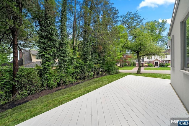 wooden terrace featuring a lawn