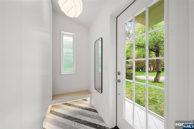 doorway featuring lofted ceiling and marble tiled floors