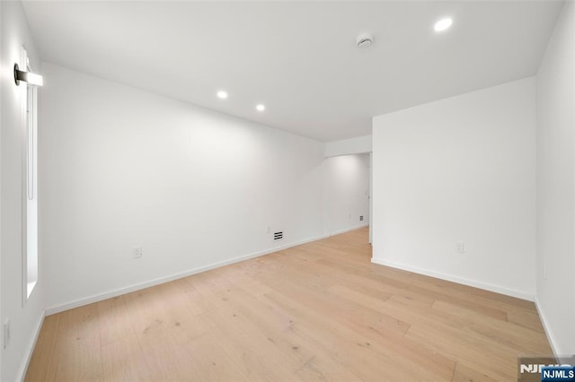 unfurnished room with recessed lighting, light wood-style floors, baseboards, and a smoke detector
