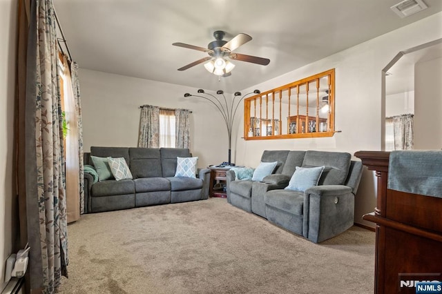 carpeted living room with ceiling fan