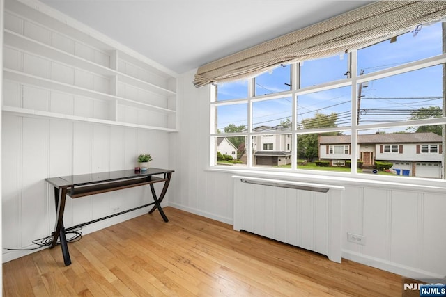 living area with light wood-type flooring and baseboards