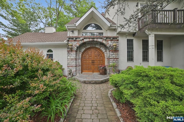 41-21 Dunkerhook Rd, Fair Lawn, NJ 07410 - doorway to property with stucco siding, stone siding, a balcony, and roof with shingles