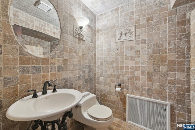 41-21 Dunkerhook Rd, Fair Lawn, NJ 07410 - bathroom with radiator heating unit, a sink, tile walls, and toilet