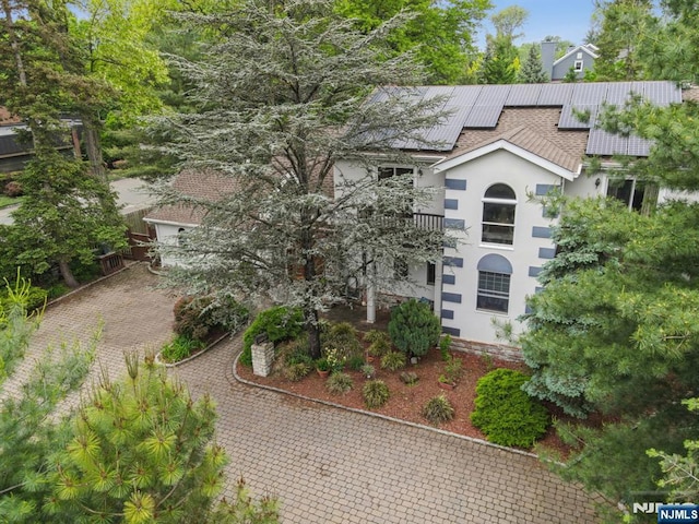 41-21 Dunkerhook Rd, Fair Lawn, NJ 07410 - view of front of house with a balcony, stucco siding, roof mounted solar panels, and roof with shingles