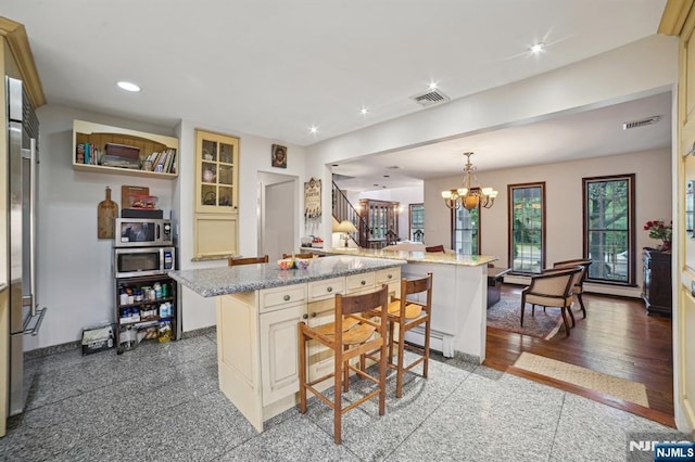 41-21 Dunkerhook Rd, Fair Lawn, NJ 07410 - kitchen featuring a breakfast bar area, a chandelier, cream cabinets, recessed lighting, and stainless steel microwave