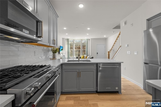 11 Arnold Dr, Wood Ridge, NJ 07075 - kitchen with appliances with stainless steel finishes, a sink, gray cabinetry, a peninsula, and recessed lighting