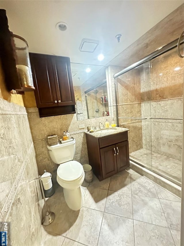 245 Prospect Ave Unit 5B, Hackensack, NJ 07601 - bathroom featuring a shower stall, toilet, tile walls, and vanity