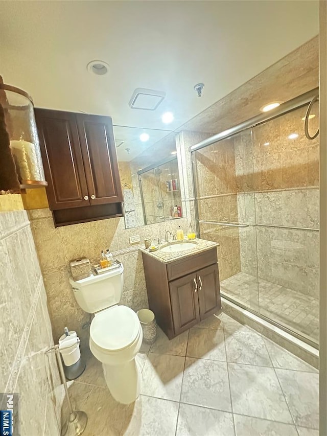 245 Prospect Ave Unit 5B, Hackensack, NJ 07601 - bathroom with tile walls, a shower stall, toilet, vanity, and recessed lighting