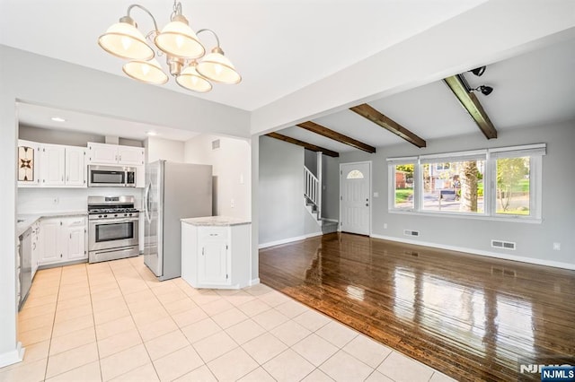 132 Hiawatha Blvd, Oakland, NJ 07436 - kitchen featuring stainless steel appliances, a chandelier, beam ceiling, baseboards, and white cabinetry