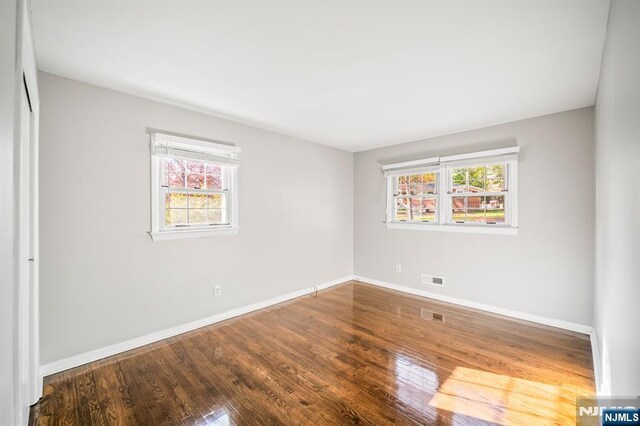 132 Hiawatha Blvd, Oakland, NJ 07436 - unfurnished bedroom featuring multiple windows, baseboards, wood finished floors, and a closet