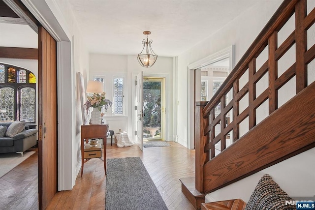 entryway featuring light wood finished floors and a chandelier