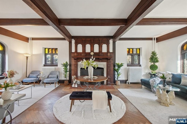 living area with radiator heating unit, beam ceiling, a fireplace, arched walkways, and coffered ceiling