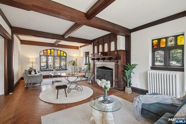 living room with radiator heating unit, baseboards, a fireplace, and beamed ceiling
