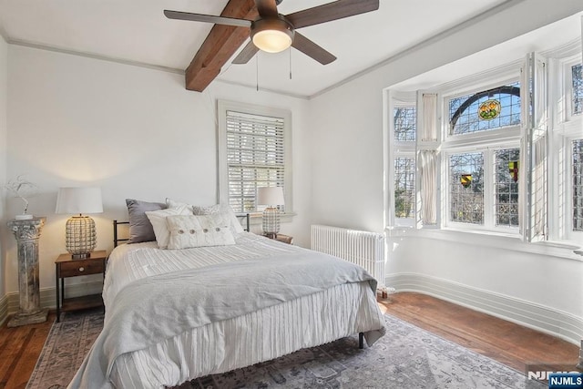 bedroom with radiator, wood finished floors, baseboards, and beamed ceiling