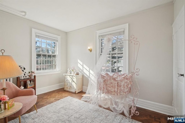 living area with baseboards and crown molding