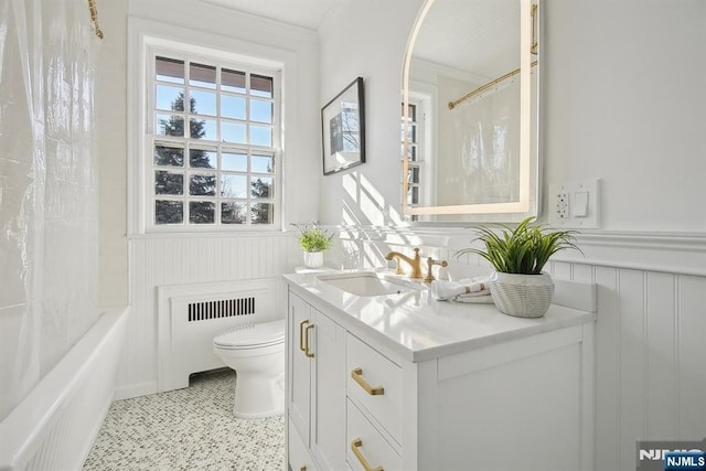 bathroom with toilet, a wainscoted wall, vanity, shower / bath combo, and crown molding