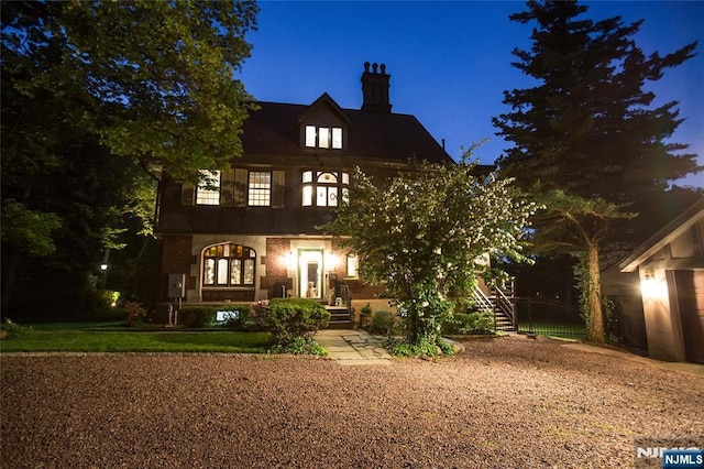back of house at twilight with a chimney