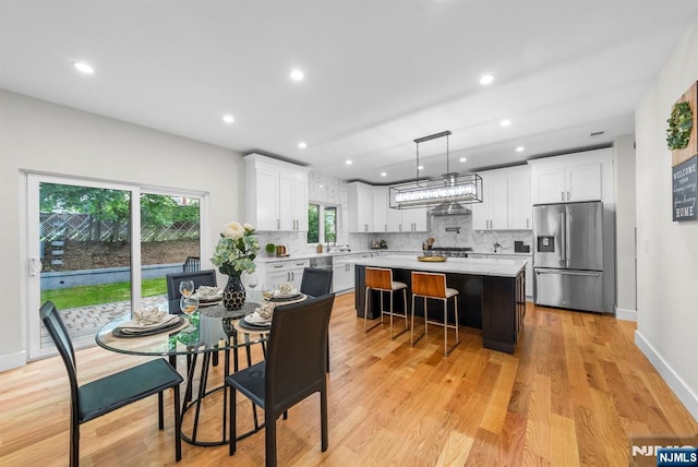 dining space featuring light wood-style floors, recessed lighting, and baseboards